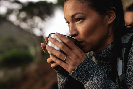 Female hiker taking rest and drinking coffee