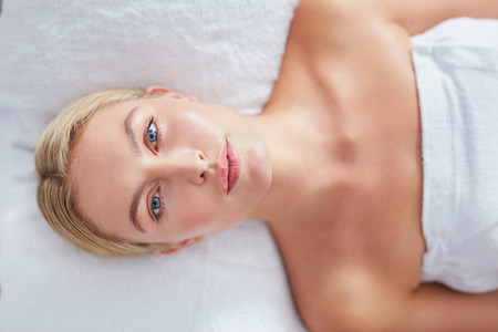 Pretty woman lying on massage table at dayspa