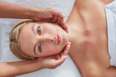 Beautiful woman having a face massage at health spa