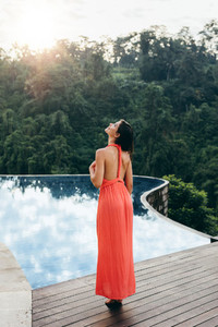 Young female model standing on the edge of pool