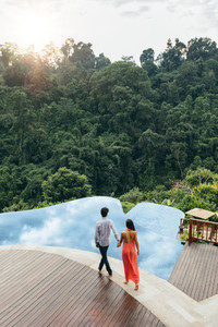 Young couple walking towards pool at luxury resort