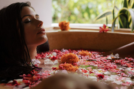 Young woman having flower bath