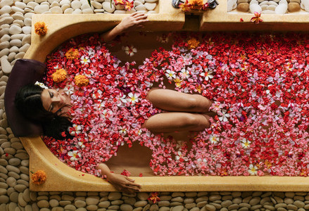 Woman having flower bath at health spa