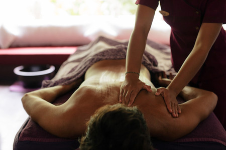 Man receiving back massage at health spa