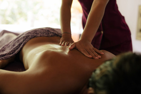 Masseuse massaging man at health spa