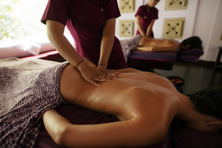 Couple receiving massage at day spa