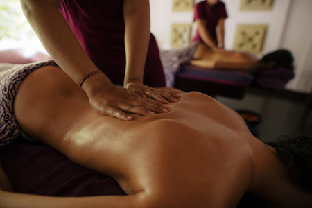 Masseuse massaging woman at health spa