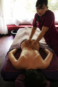 Woman getting back massage at spa resort