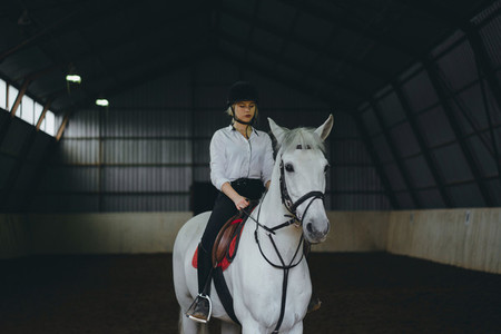 A girl on horseback riding an arena