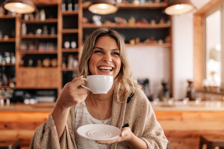 Smiling young woman having coffee