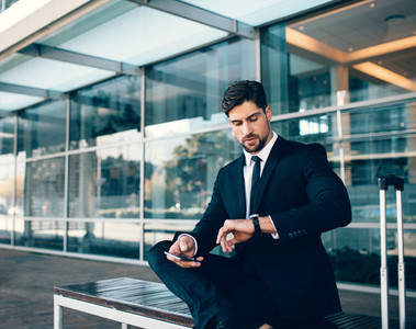 Young businessman checking time at airport