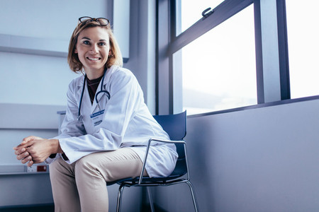 Smiling female doctor sitting in hospital room