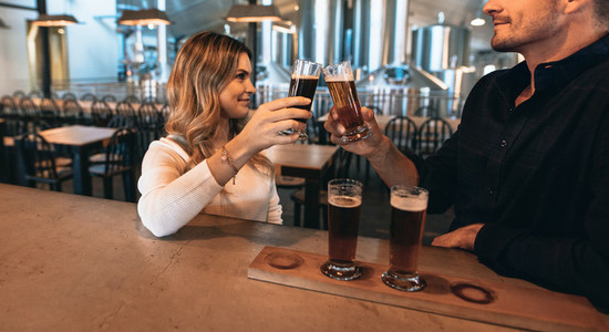 Couple at the bar with different varieties of craft beers