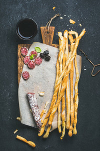 Grissini bread sticks sausage olives and red wine copy space