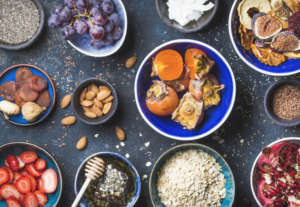 Ingredients in bowls for healthy breakfast over dark blue background