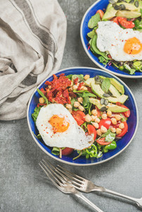 Healthy breakfast with fried egg  chickpea  vegetables  seeds and greens