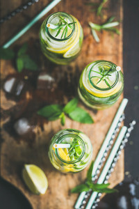 Healthy infused citrus sassi water in glass bottles with rosemary