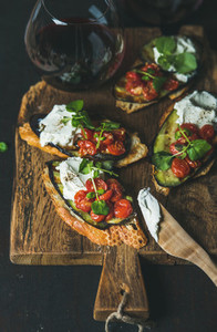 Bruschetta with grilled vegetables cream cheese arugula and red wine
