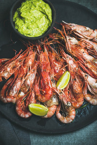 Roasted red shrimps with guacamole avocado sauce and lemon slices