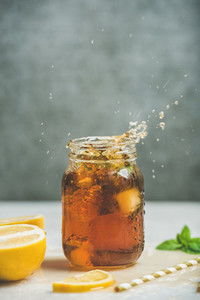 Iced tea with bergamot and mint in jar with splashes