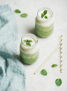 Ombre layered green smoothies with mint in glass jars
