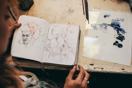 Female artist looking at sketches in her studio