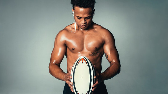 Model with strong body holding rugby ball