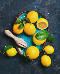 Freshly picked lemons with leaves in blue ceramic plate