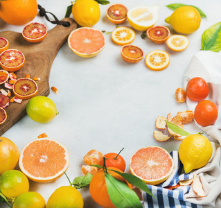 Citrus fruits slices on wooden board over grey marble background