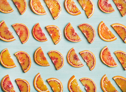 Fresh juicy blood orange slices over blue painted table background