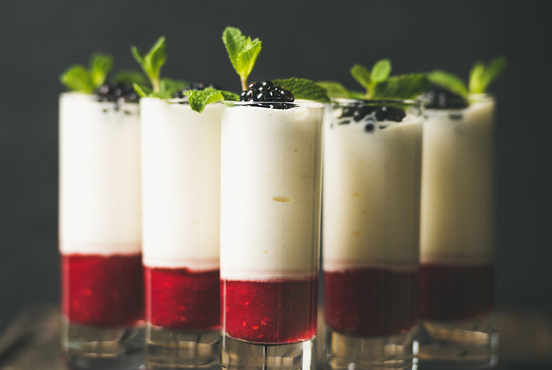 Dessert in glass with blackberries and mint, copy space
