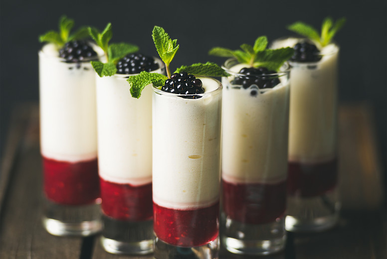 Homemade desserts with fresh blackberry and mint over dark background