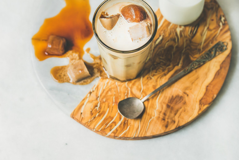 Iced caramel latte coffee cocktail with milk in glass