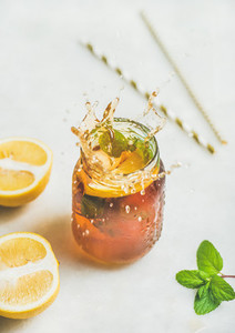 Summer cold Iced tea with lemon and herbs vertical composition