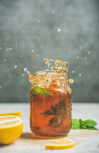 Iced tea with bergamot lemon mint in jar with splashes