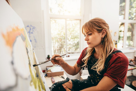 Creative female artist drawing picture in her studio