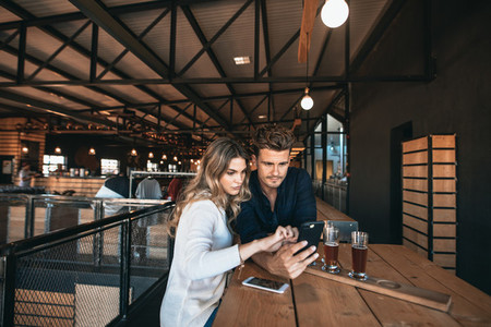 Couple at the bar using mobile phone