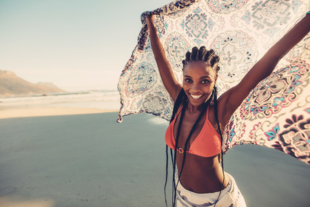 African female standing on the seaside with scarf