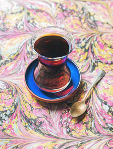 Turkish tea in traditional oriental tulip glass over colorful background