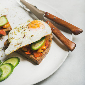 Breakfast toast with fried eggs  vegetables  square crop