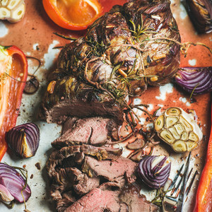 Cooked Roastbeef meat with vegetables and herbs in baking tray