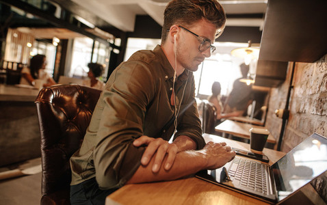 Young man sitting at startup using laptop