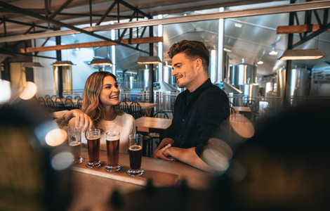 Couple at brewery bar and tasting beer