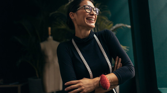 Female fashion designer laughing in her studio