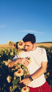 Young man hugging a sunflower