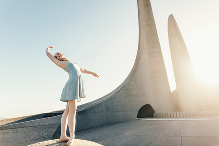 Female ballet dancer practicing dance moves on a rock
