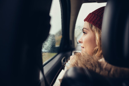 Woman traveling by car and looking outside window