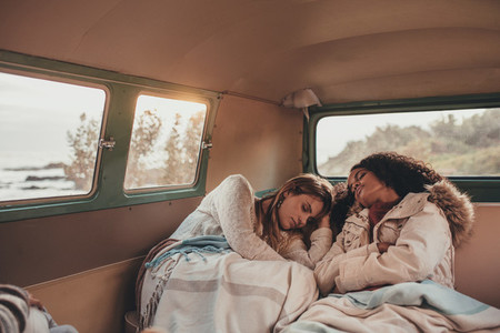 Women friends sleeping in the van
