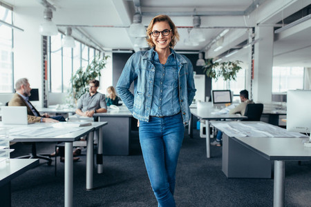 Cheerful businesswoman standing in office environment