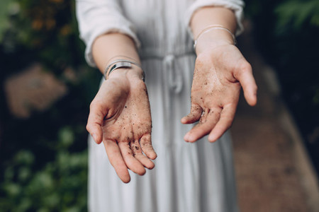 Woman with hands covered in dirt